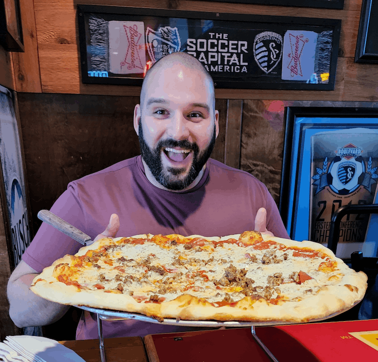 Me posing with a massive pizza.